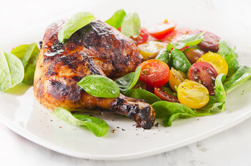 Roasted chicken leg with fresh vegetables.