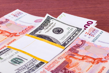Пачки денег  на деревянном фоне: рубли, доллары и евро