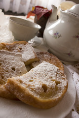 French toast with sprinkled sugar powder on top and a cup of hot tea 
