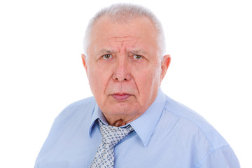 Close-up portrait of serious and strict senior old businessman, dressed in blue shirt and tie, isolated on white background. Human emotions and facial expressions
