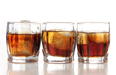 Glass cups with whiskey on white background