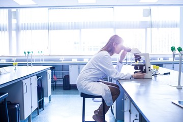 Scientist working with a microscope in laboratory