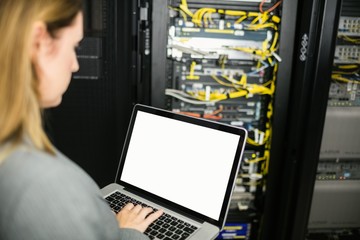 Technician using laptop to analyse server