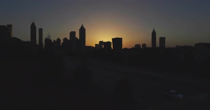 Atlanta City Skyline Tilt Up after Sunset. camera tilts up to reveal atlanta city skyline after the sun set. orange glow in the middle  silhouettes buildings
