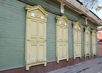 Obraz na płótnie Canvas The wooden house with closed window shutters on Irkutsk street