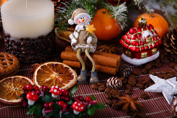 Xmas or new year composition with holiday decoration - Homemade X-mas cupcakes, sliced dried oranges on wooden background with spruce twigs. Little man figures. Christmas card