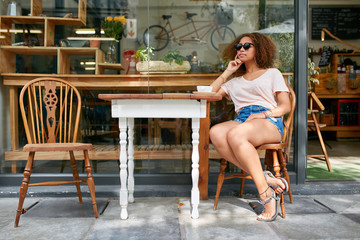 Obraz na płótnie Canvas Young african woman sitting at coffee shop