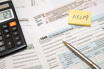 Tax Form 1040, U.S. Individual income tax return place with calculator and pen