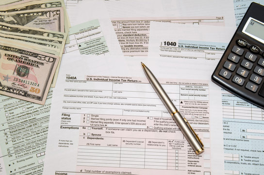 Filing federal taxes for refund - tax form 1040,  calculator, pen, dollar