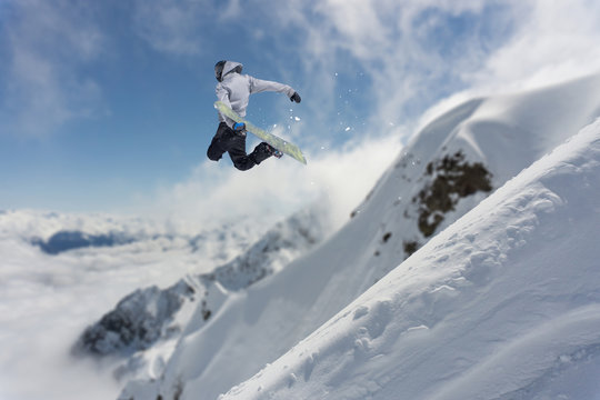 Flying snowboarder on mountains. Extreme sport