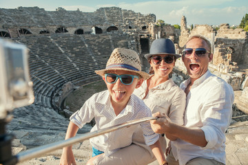 Young positive famly take a vacation photo on the Side ampitheat