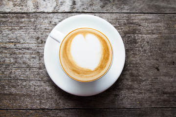 Cup of hot latte art coffee on wooden table,selective focus