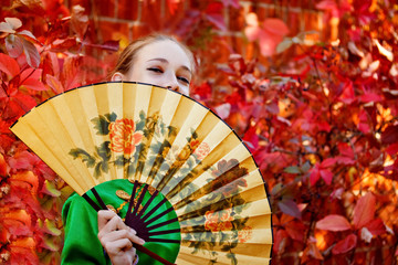 A girl holds a Chinese fan