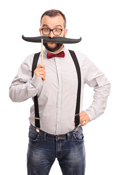 Happy hipster holding a fake mustache