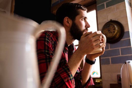 Handsome hipster relaxing in kitchen