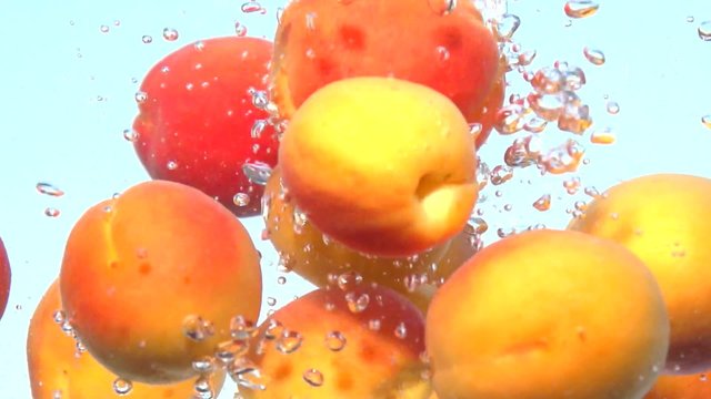 Apricot. Fresh and ripe organic apricots falling in water. Bio Fruits. Slow motion 240 fps. 