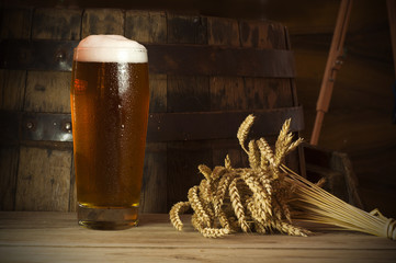 Beer barrel with beer glass on table on wooden background