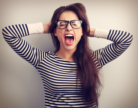 Angry young business woman in glasses strong screaming with wild