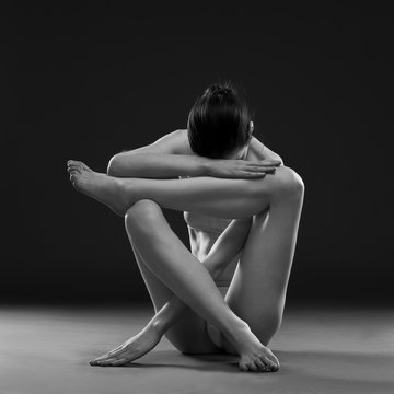 Fototapeta Naked yoga. Beautiful sexy body of young woman on gray background