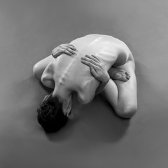 Fototapeta premium Naked yoga. Beautiful sexy body of young woman on gray background