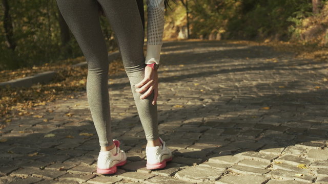 Sport running ankle sprain. Sportswomen touching painful twisted ankle. 