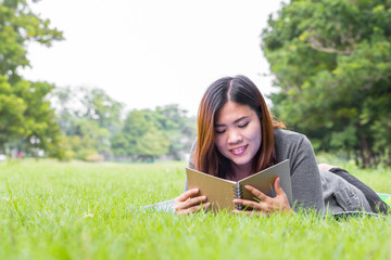 Asian woman reading a book in the park