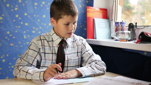 Teenage boy sitting and preparing his homework