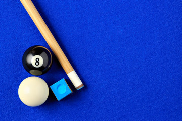 Naklejka premium Billiard balls, cue and chalk in a blue pool table.