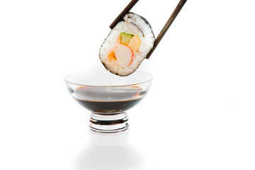 Dipping roll in sauce isolated on white