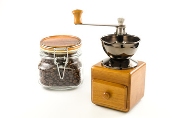coffee grinder and roasted coffee beans in glass bottle