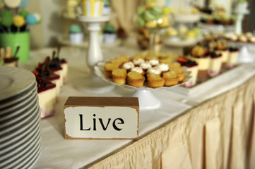 Sweets corner with LIVE inscription on the table
