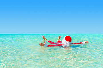 Santa Claus swimming in ocean water, Christmas concept