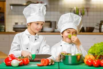 Funny happy chef boys cooking at restaurant kitchen. concept of vegetarianism