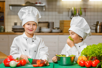 Funny happy chef boys cooking at restaurant kitchen. concept of vegetarianism