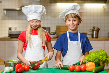 Funny happy chef boy and girl cooking at restaurant kitchen. concept of vegetarianism