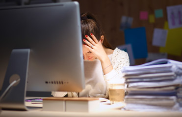 Young and beautiful businesswoman tired from work in the office