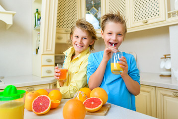 Children with citrus. Boys drink fresh orange juice - 96625412