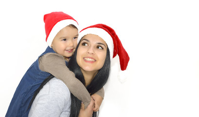christmas, family, childhood and people concept - happy mother and little girl in santa hats over holidays isolated on white