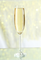 Glass of champagne on lights background