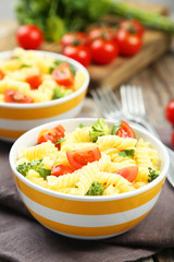 Delicious pasta in bowl on grey wooden background