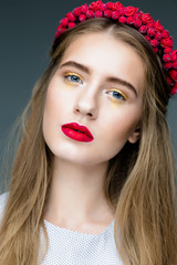 Sensual sexy woman face wearing floral red wreath and red lips