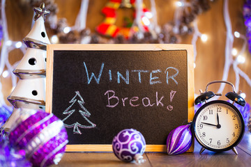Winter Break written on the black chalkboard with Christmas decorations and lights