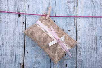 Wedding favor hanging on clothesline on old wooden background
