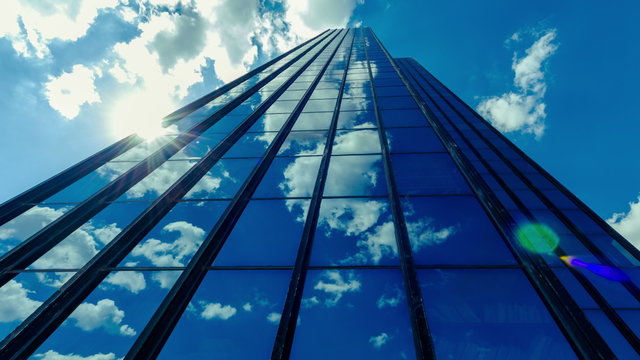 4K 25pTall corporate building timelapse,sun and clouds reflections on glass.