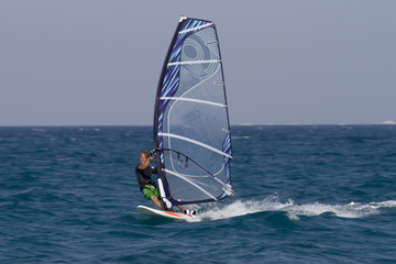 Windsurfen in &Auml;gypten, Hurghada. Mann surft im Meer mit blauem Segel.
