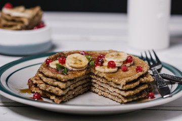Stack of healthy low carbs oat pancakes over white wooden background