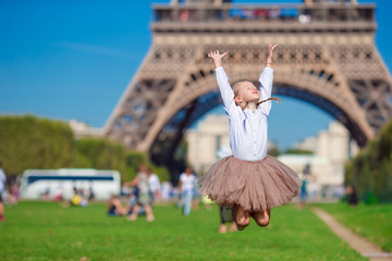 Naklejka premium Adorable little girl in Paris background the Eiffel tower during summer vacation