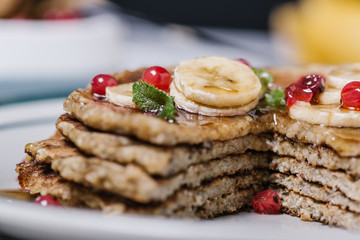 Stack of healthy low carbs oat pancakes over white wooden background