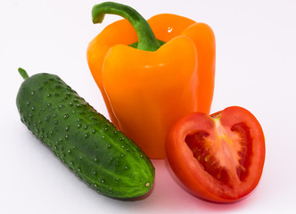 Желтый перец, красный томат и зеленый огурец на белом фоне