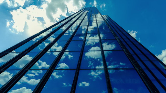 4K 30p Tall corporate building timelapse,sun and clouds reflections on glass.
